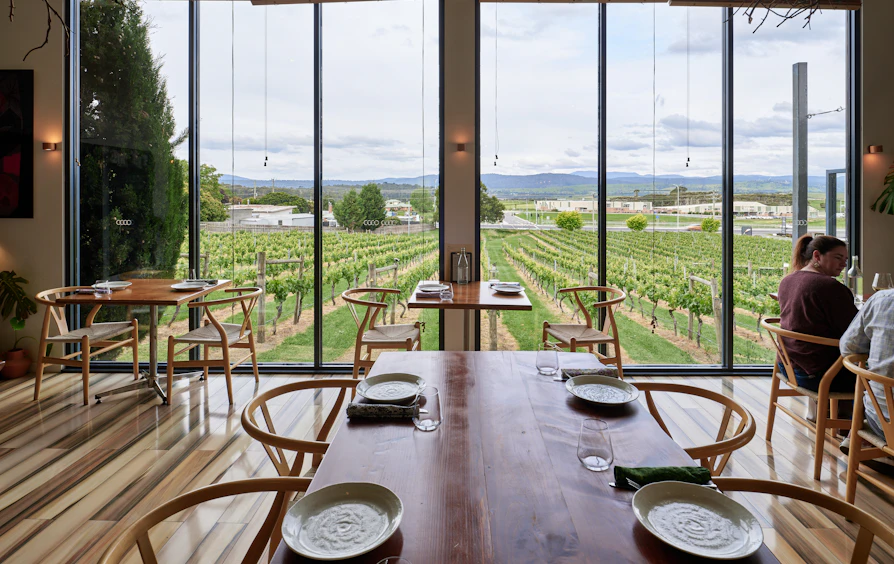 Tasting room laid for service, looking out over the vines